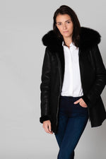 Warm black reversed sheepskin coat with fixed hood and straight fit. - Image n°1