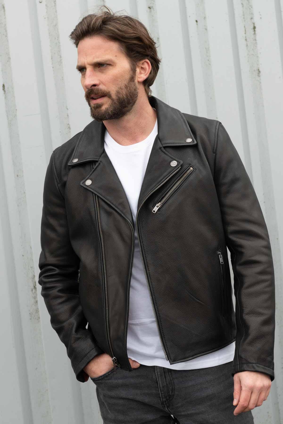 Sleek black cowhide biker jacket with zip sleeves and rivets. - Image n°1
