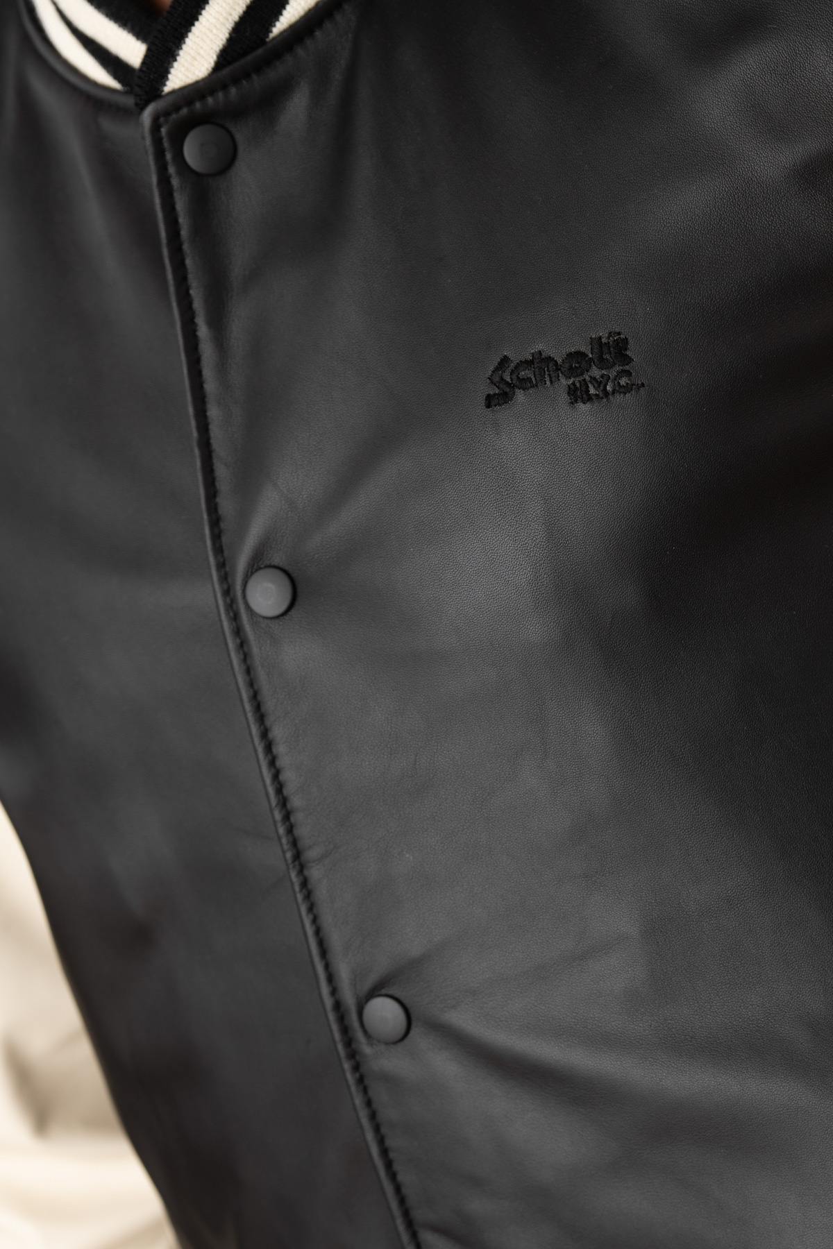 Schott's varsity-style lambskin jacket in black and off-white. - Image n°7