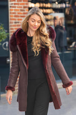 Luxurious wine red shearling jacket, fox fur hood, rashed lamb warmth. - Image n°1