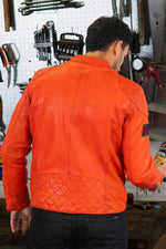 Bold orange lambskin moto jacket with quilted shoulders and patches. - Image n°4