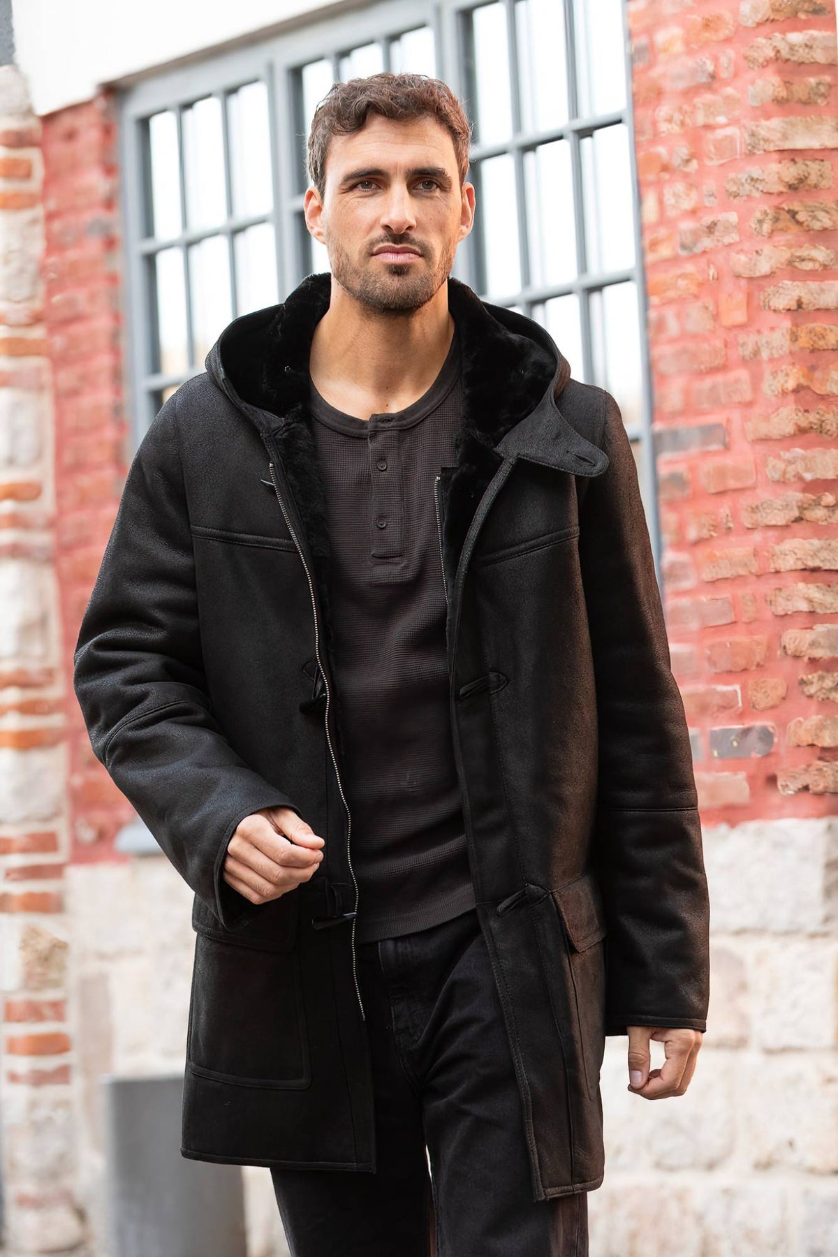 Black hooded long coat in shearling leather - Image n°1