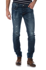 Raw blue jeans faded and with holes - Image n°1