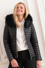 Black sheepskin jacket with glossy quilted look. Racoon fur hood trim. - Image n°1