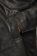 Black lambskin parka with detachable vegan-fur hood for urban warmth. - Image n°5