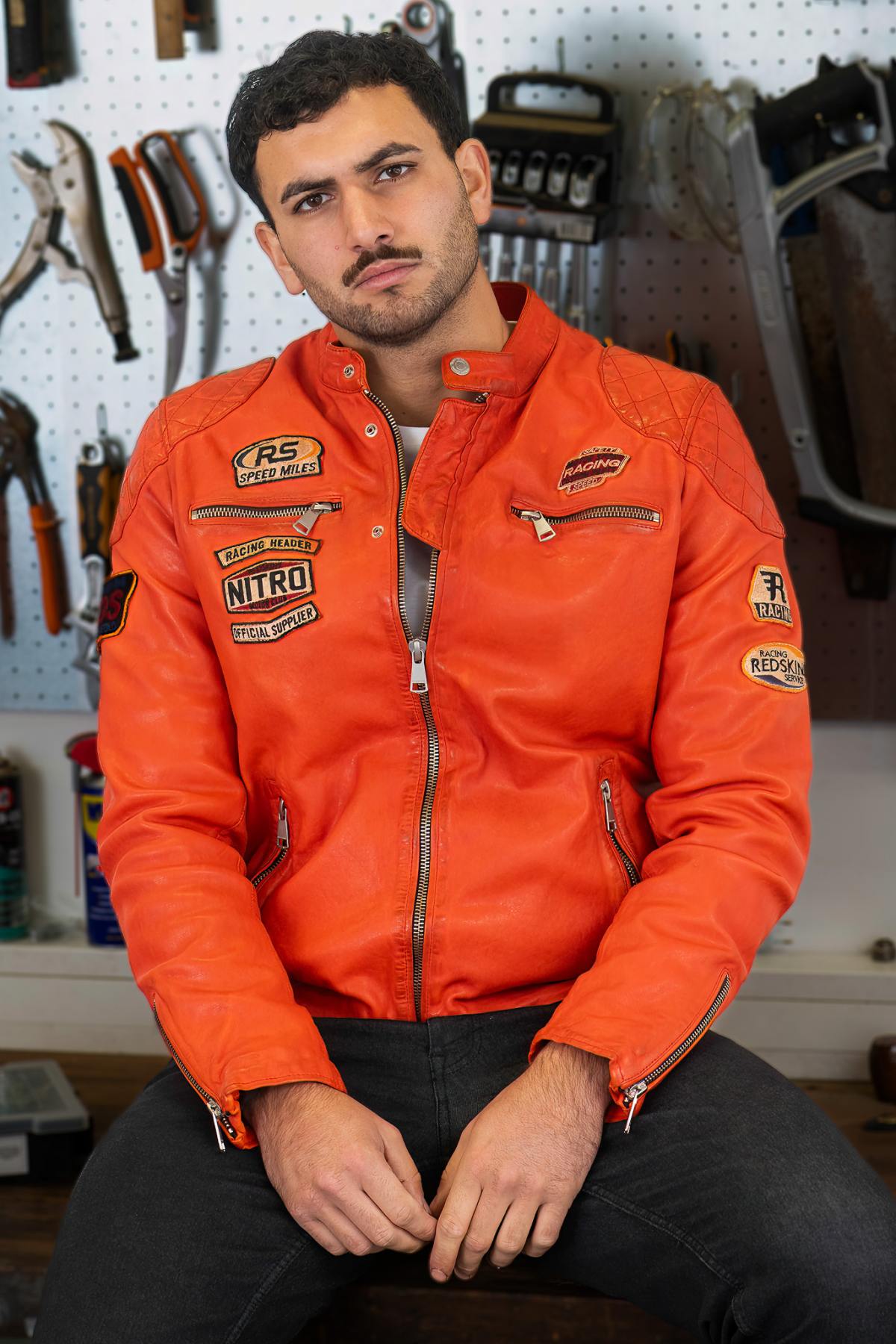 Bold orange lambskin moto jacket with quilted shoulders and patches. - Image n°1