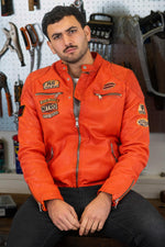 Bold orange lambskin moto jacket with quilted shoulders and patches. - Image n°1