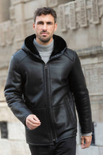 Black hooded long coat in shearling leather - Image n°1